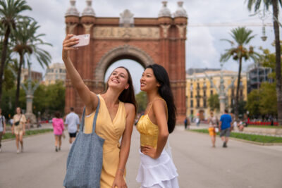 Stylish diverse girlfriends taking selfie in city